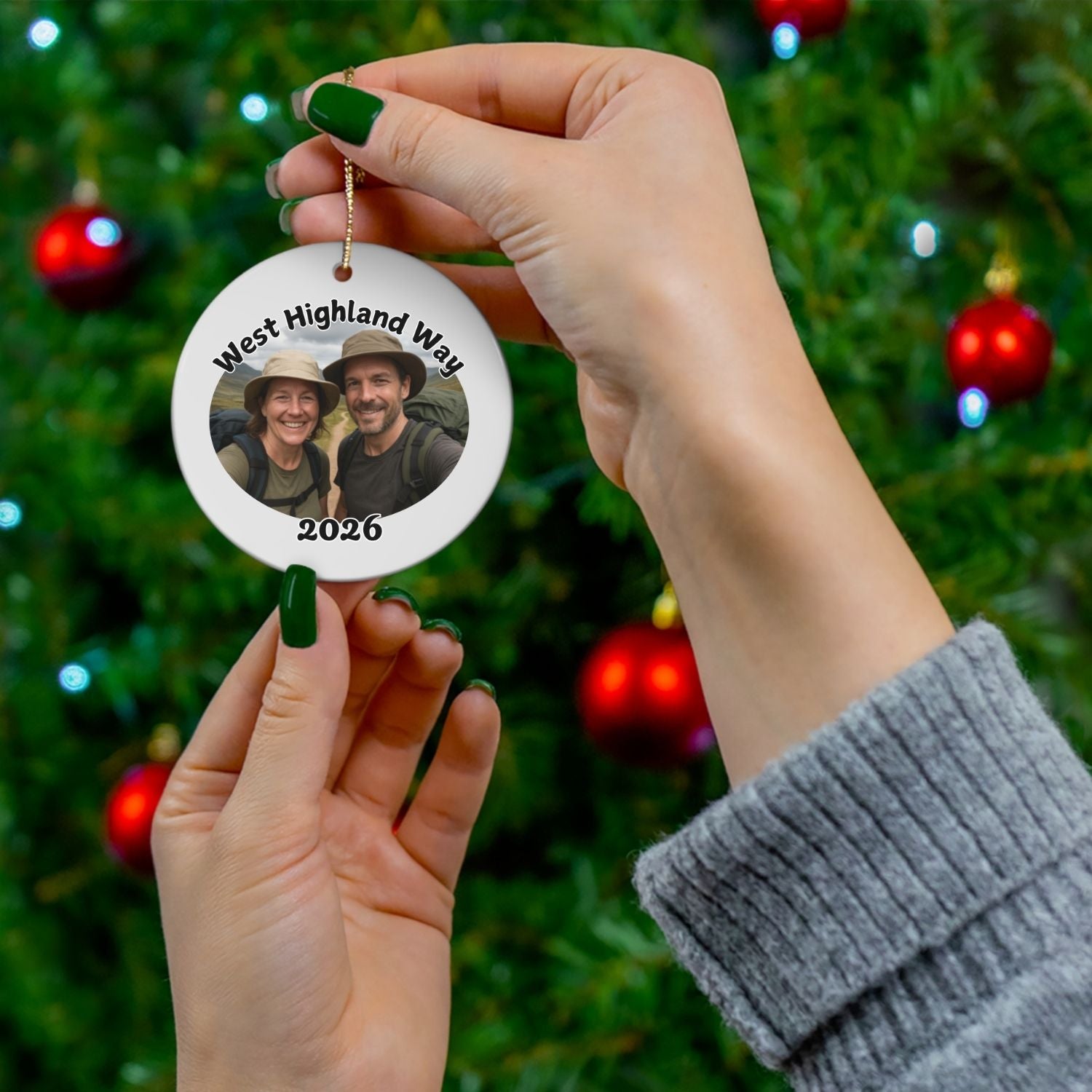 A photo version of the ornament held between hands or size comparison in front of a christmas tree.